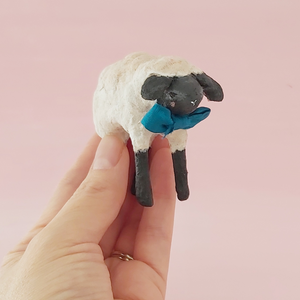 Vintage style miniature spun cotton sheep held in hand against a pink background. Pic 2 of 8.