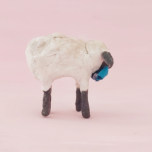 A side view of a vintage style miniature spun cotton sheep, against a pink background. Pic 6 of 8.
