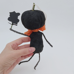 Back view of vintage style spun cotton black jack-o'-lantern, held in hand on a white background. Pic 6 of 8. 
