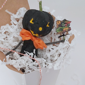 Vintage style spun cotton black jack-o'-lantern sitting in white gift box, surrounded by white tissue shredding on a white background. Pic 4 of 8. 