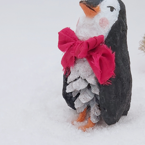 Close-up of the penguin's glittery white pine cone body and red bow tie. Pic 6 of 10. 