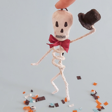 Load image into Gallery viewer, A vintage style spun cotton skeleton ornament standing on Halloween confetti against a light blue background. Pic 1 of 6.
