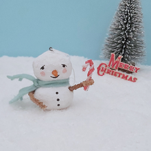 Cargar imagen en el visor de la galería, Vintage style spun cotton snowman, holding candy cane and standing on snow against a light blue background. A bottle brush tree and Merry Christmas decoration are in the distance. Pic 2 of 7.
