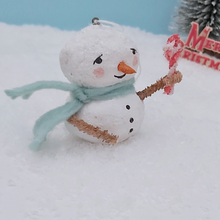 Cargar imagen en el visor de la galería, Closer view of spun cotton snowman, standing on snow and holding a pipe cleaner candy cane. Pic 4 of 7.
