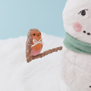 A close up of a tiny spun cotton robin that the spun cotton snowman is holding. Pic 3 of 7. 