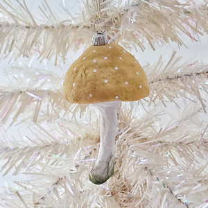 A vintage style spun cotton yellow mushroom ornament, hanging from a white tree. Pic 2 of 4